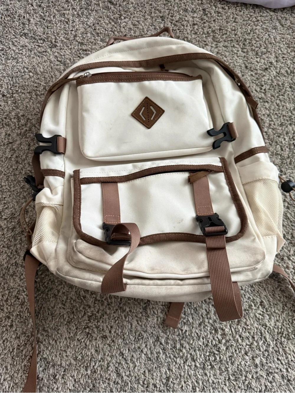 cream and brown colored backpack